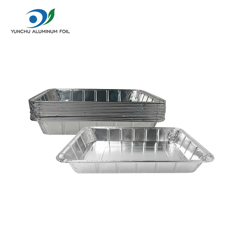Velké grilované ryby s sebou stříbrné hliníkové fólie nádoby