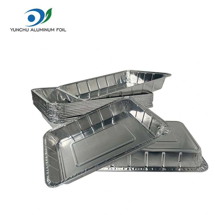 Velké grilované ryby s sebou stříbrné hliníkové fólie nádoby